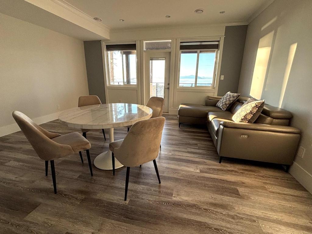 ein Wohnzimmer mit Tisch, Stühlen und Sofa in der Unterkunft Ocean Whispers in Nanaimo