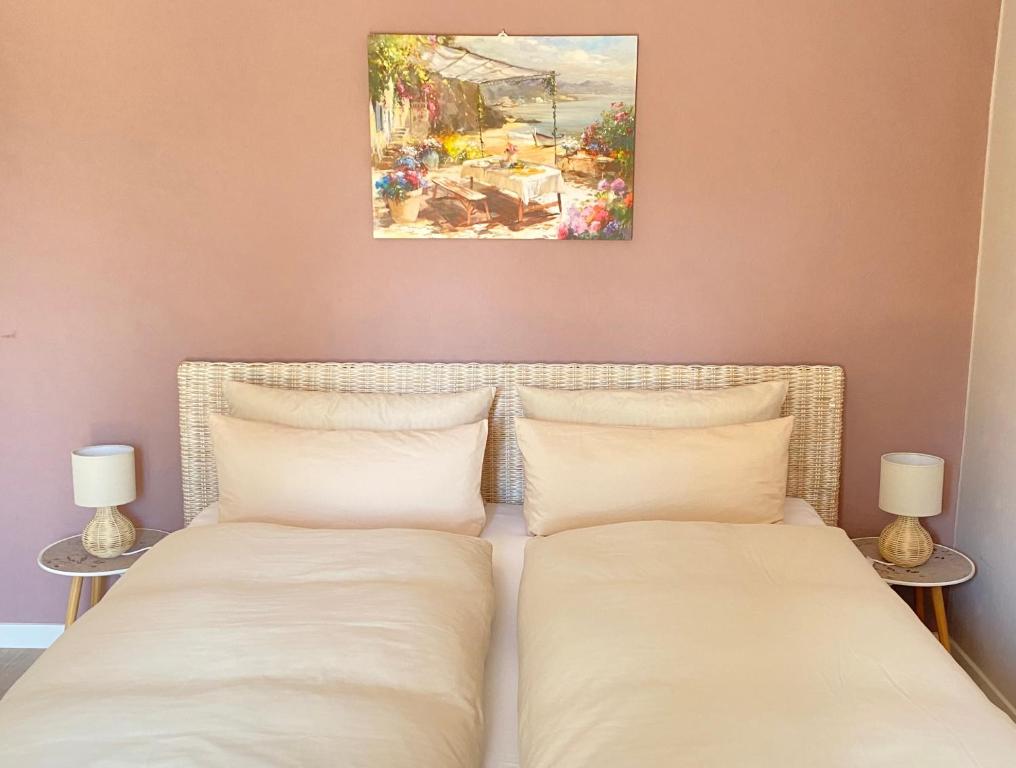 two beds in a bedroom with a painting on the wall at Apartment am Golfplatz in Obernkirchen