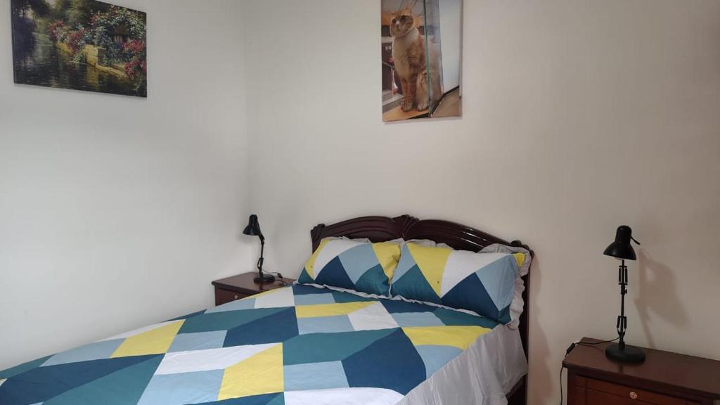 a bedroom with a colorful bed with two lamps at Piedra Marina Bahia in Bahía de Caráquez