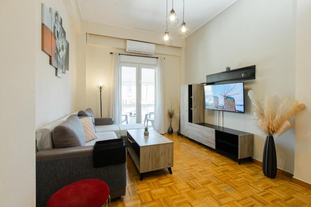 a living room with a couch and a flat screen tv at Feel's Like Home Apartment in Chios Town in Chios