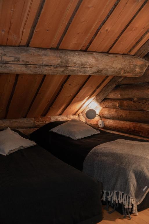 a room with two beds in a wooden attic at Pikkukelo Ruka in Ruka