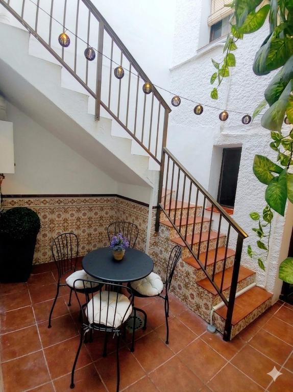 a patio with a table and chairs and stairs at Casa Marbella in Fuengirola