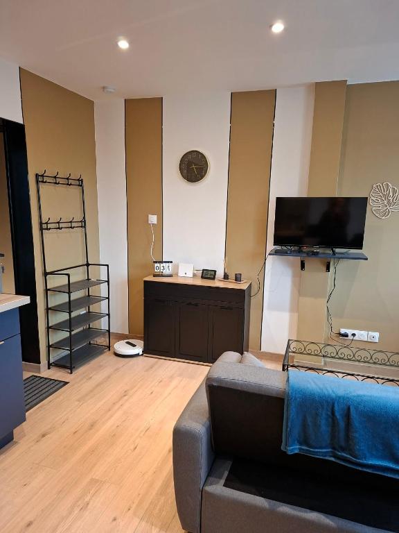a living room with a couch and a flat screen tv at horizon doux in Calais