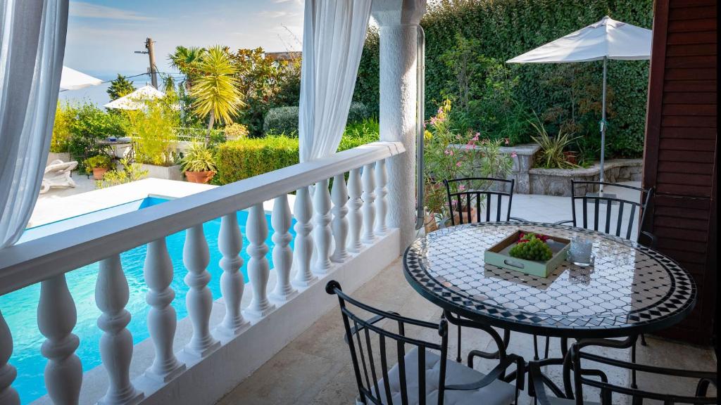 a balcony with a table and chairs and a pool at Apartments Barbara in Lovran
