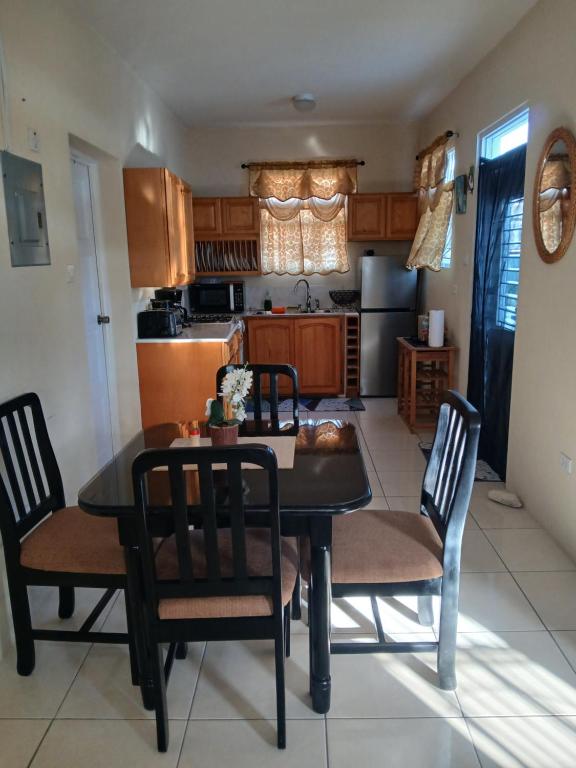 a kitchen and dining room with a table and chairs at Cozy Suite, Wifi, Ac in Bedroom & 1 Minute Walk to West Coast Beach! in Saint James