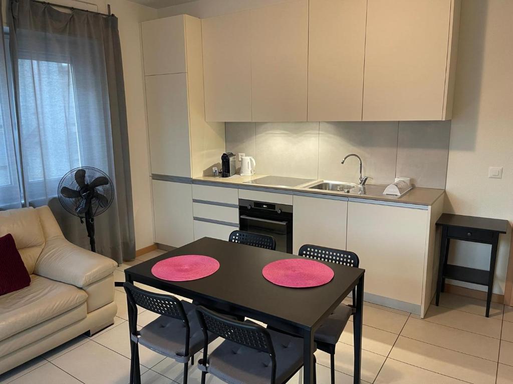 a kitchen with a table and chairs and a kitchen with a couch at Balerna Swiss Apartment by RentuGoo Travel in Balerna