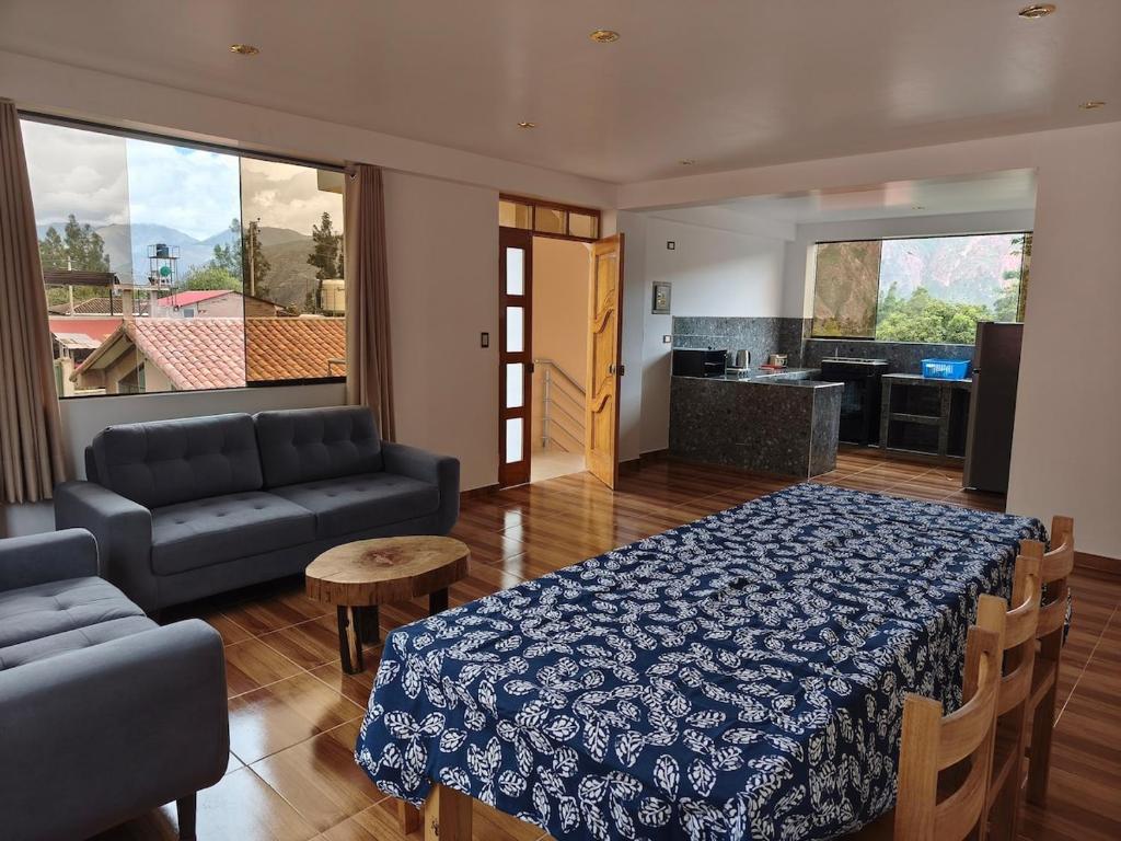 a room with a bed and a couch and a kitchen at Depa Urubamba in Urubamba