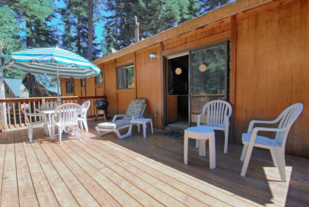 a deck with chairs and tables and an umbrella at Villa Bossi in Carnelian Bay
