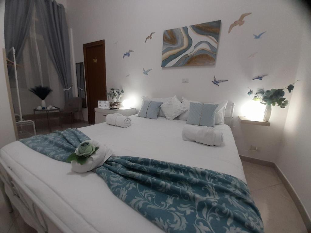 a large bed in a bedroom with birds on the wall at Falanga Family Guests Accommodation in Civitavecchia