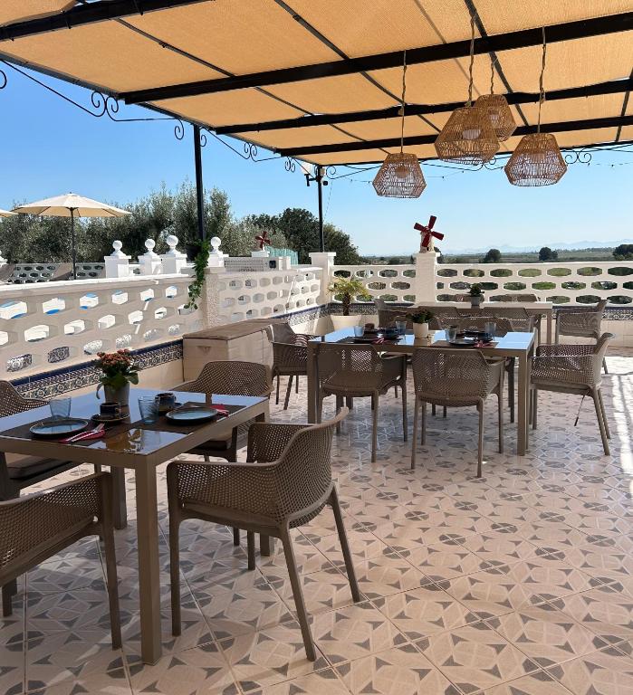 a restaurant with tables and chairs and a cross on the wall at Finca Tres Molinos B&B in Roldán