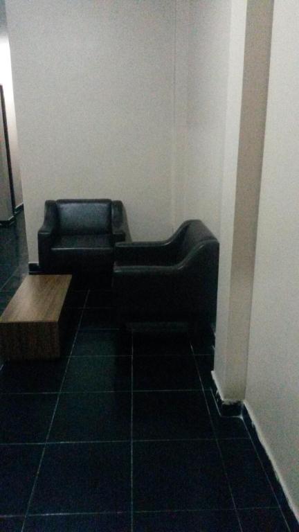 a black couch sitting in a corner of a room at Hotel Okada (Adults Only) in São Paulo