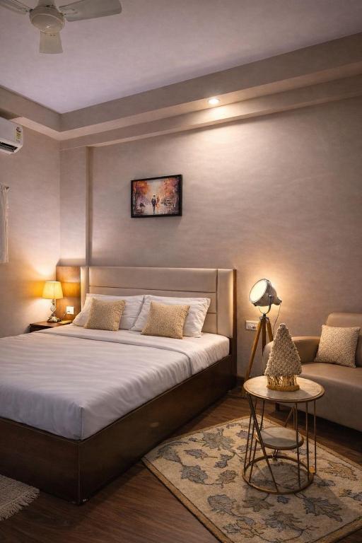 a bedroom with a large bed and a couch at StayScape studio in Greater Noida