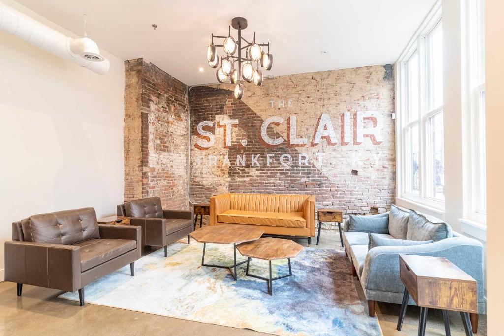 a living room with couches and a brick wall at The Saint Clair in Frankfort