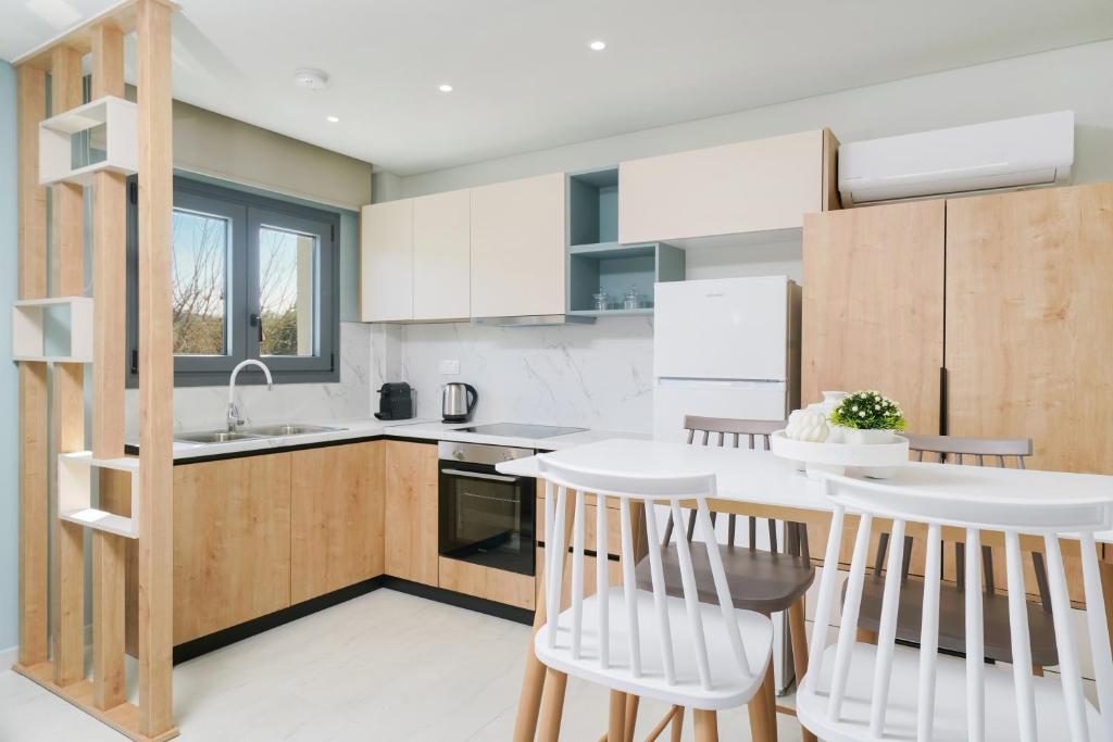 a kitchen with white cabinets and a kitchen island with chairs at Hibiscus Suites in Potos
