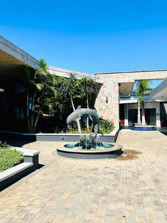 a statue in a courtyard in front of a building at Spacious 3 Bedroom Apartment in Ballito Hills Lifestyle Estate Near Ballito Beach in Ballito