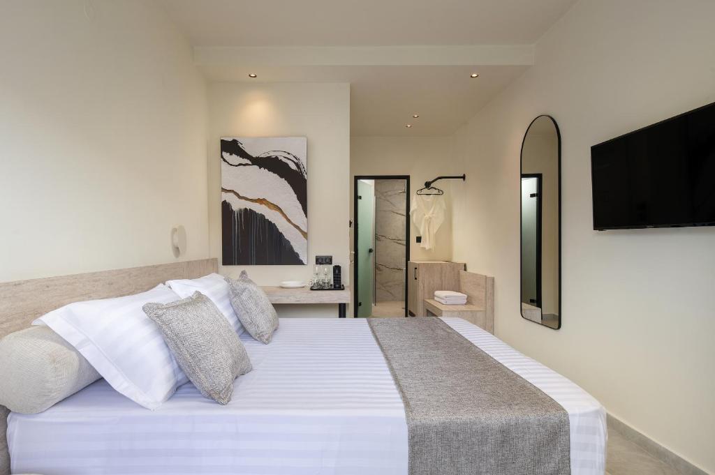a bedroom with a white bed with a television on the wall at Phos Luxury Living in Sarti