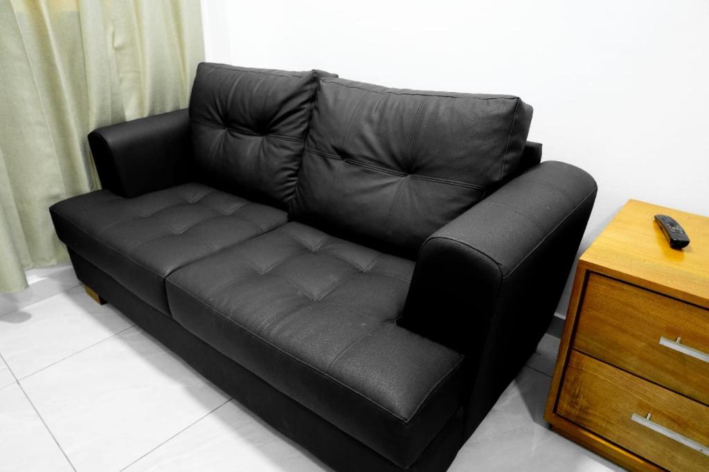 ein schwarzes Ledersofa im Wohnzimmer in der Unterkunft Hotel Bimini in Constanza
