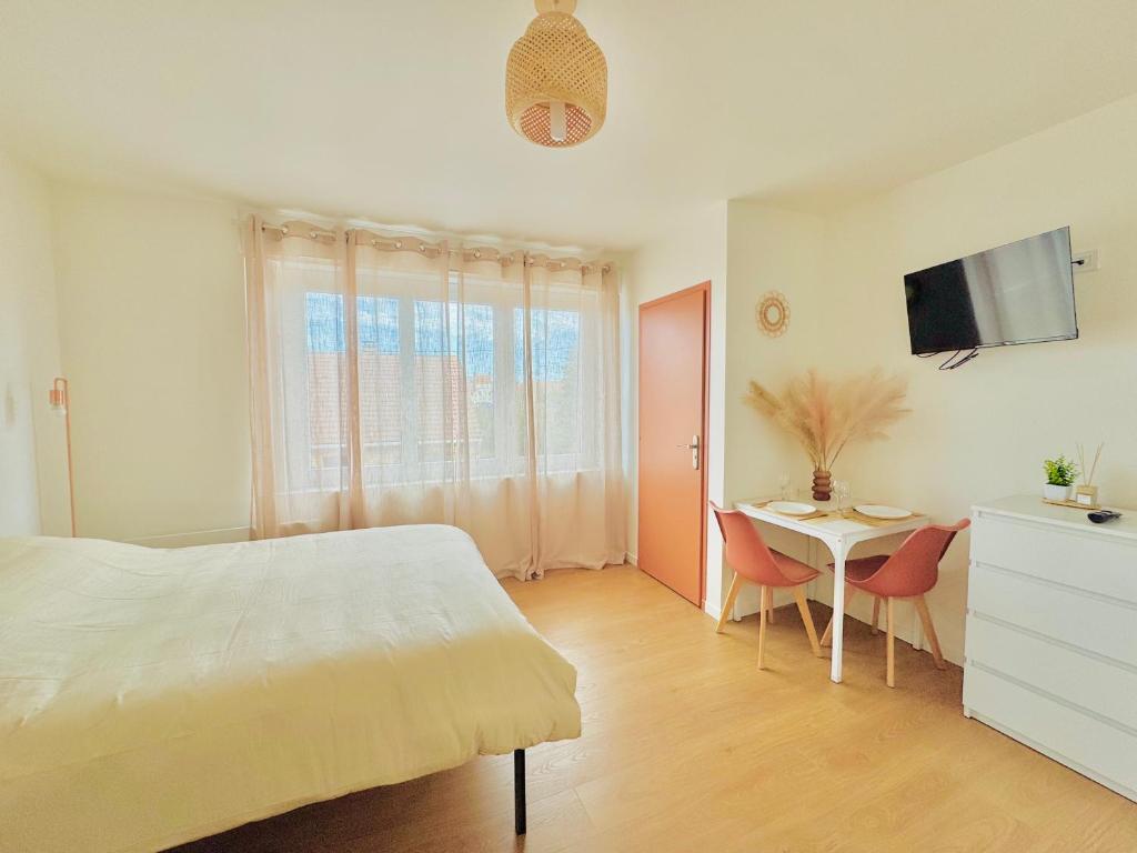 a bedroom with a bed and a table with chairs at Dreamz in Calais