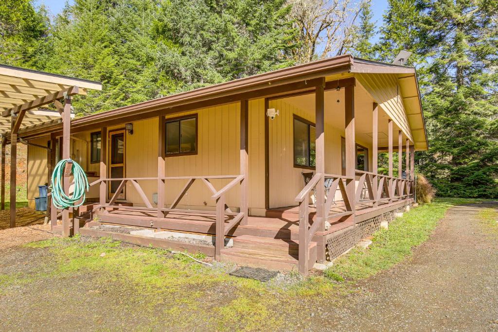 a small yellow house with a large wooden porch at Creative Escape! Eagle's Nest Hideaway in Cottage Grove