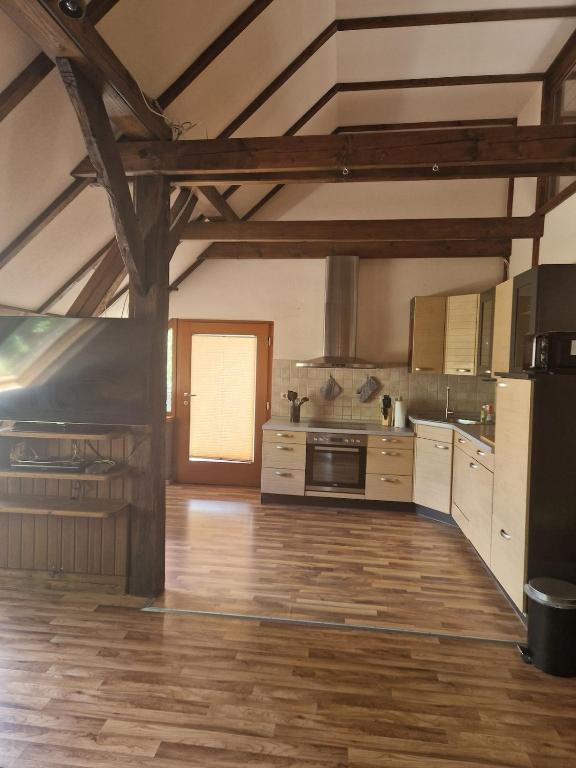a large kitchen with wooden floors and wooden beams at Monteurs Wohnung in Andervenne in Andervenne Oberdorf