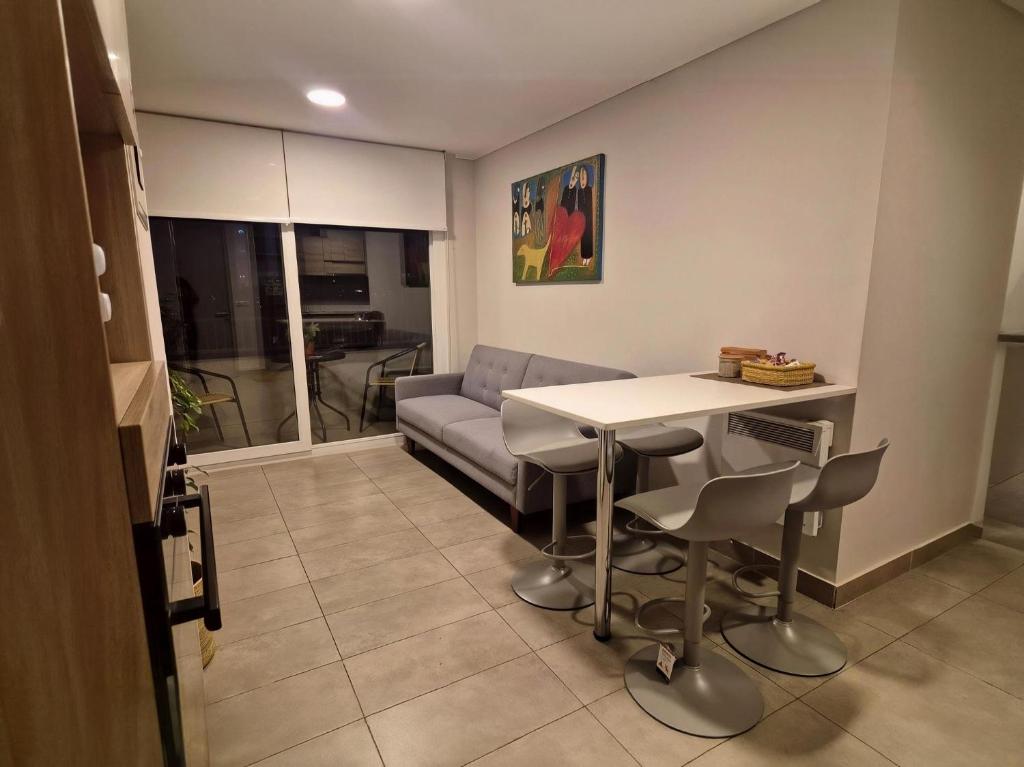 a living room with a couch and a table and chairs at Depto cómodo y central in Temuco
