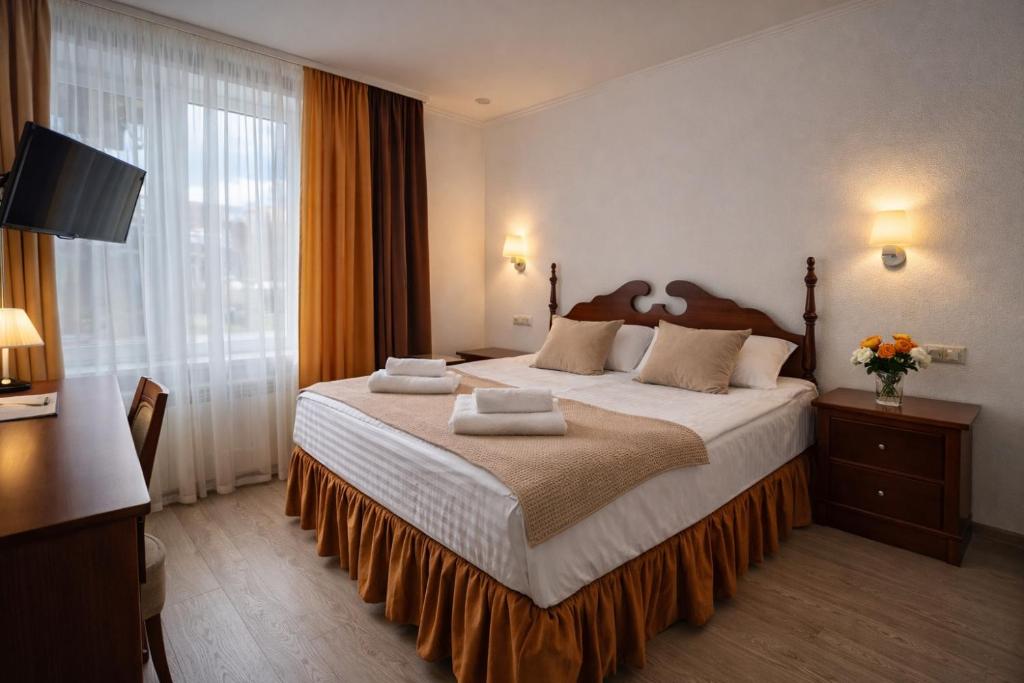 a hotel room with a large bed and a television at Gusarskiy Hotel and Apartment in Kyiv