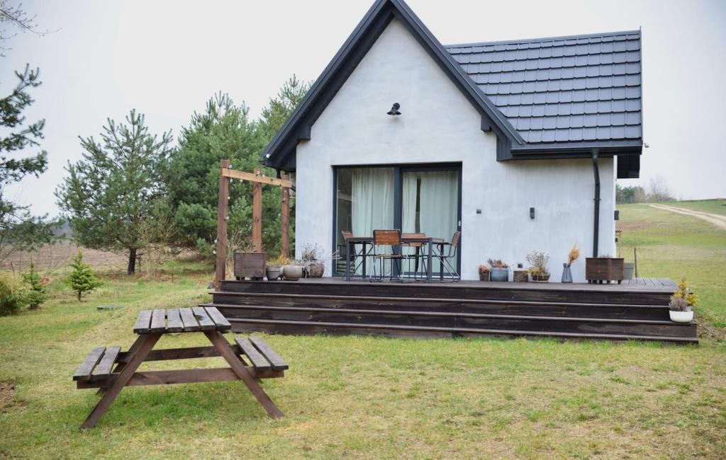 a white house with a picnic table in front of it at Domki na polance in Horyniec