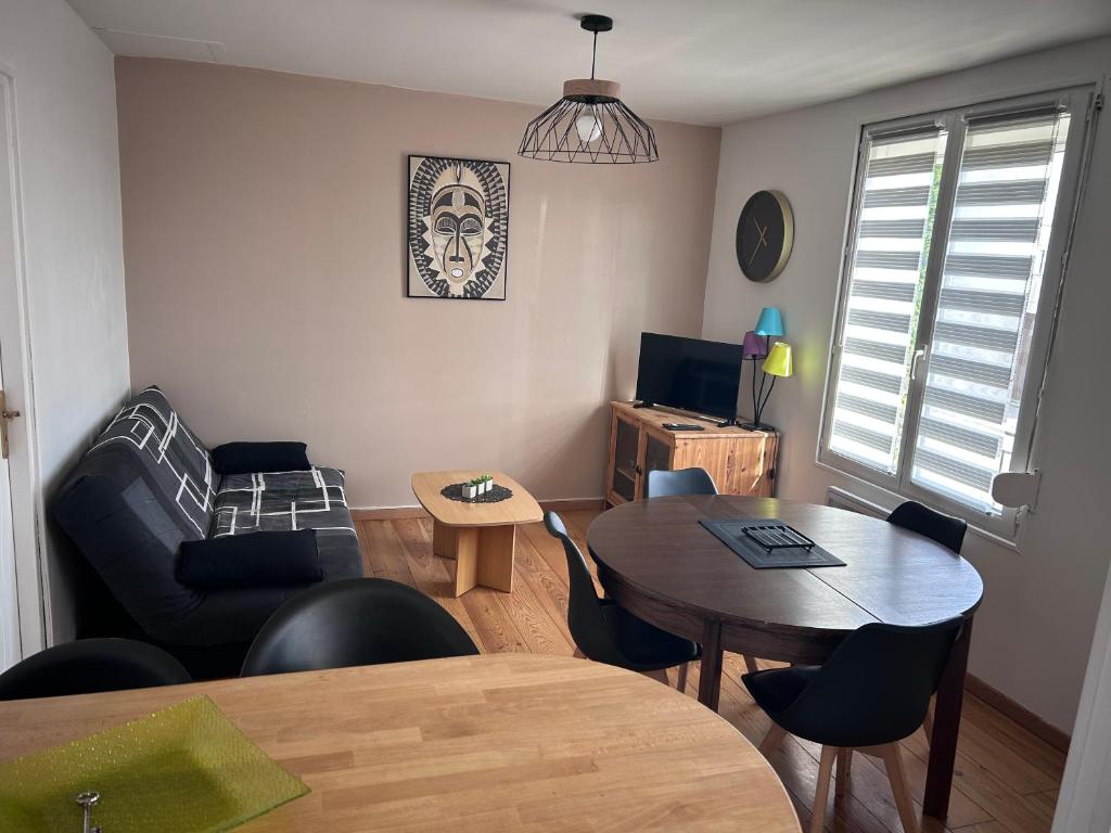 a living room with a table and a couch at Villa Juliette in Le Tréport