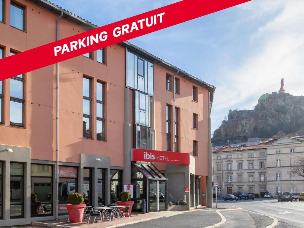 a building with a sign that reads parking gruthnir at ibis Le Puy-en-Velay Centre in Le Puy-en-Velay