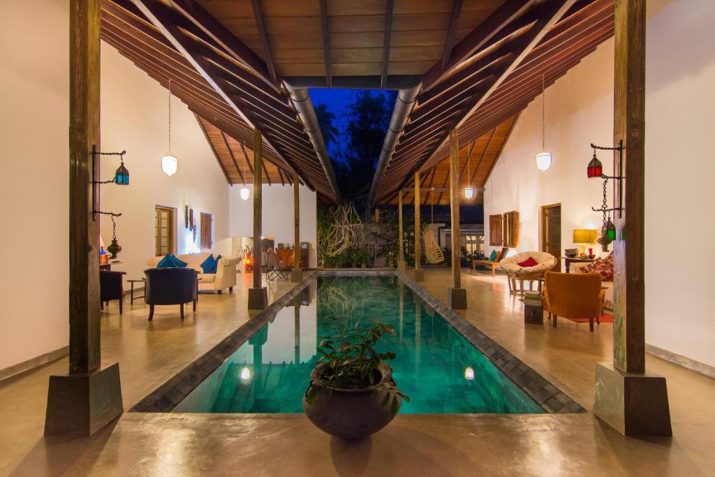 a swimming pool in a house with a living room at The Kandyan Manor by Bhathiya & Suzy in Kandy