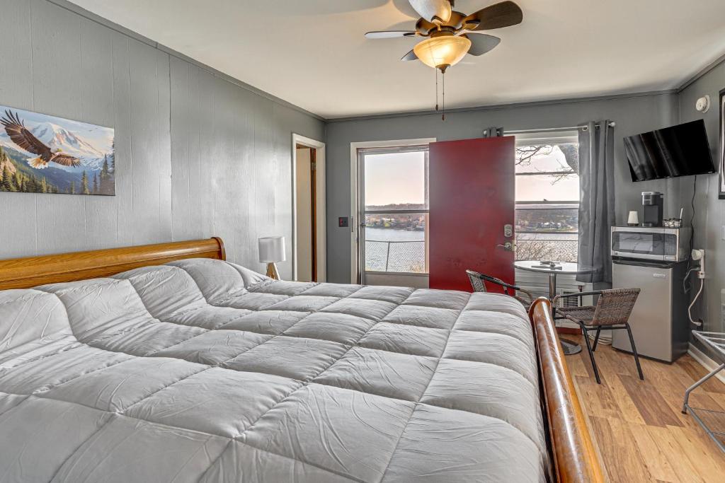 a bedroom with a large bed with a ceiling fan at Lake Ozark Stay for Shootout Weekend in Lake Ozark