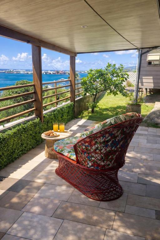 a bench on a patio with a view of the ocean at Tahiti Roa Lodge Faaa in Faaa