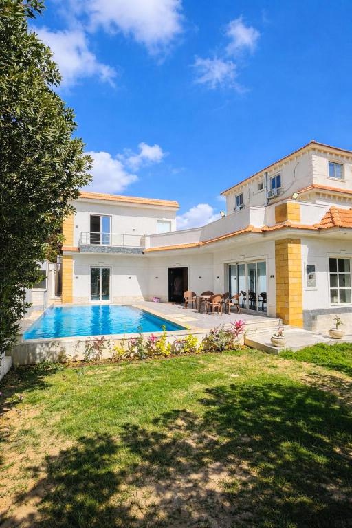 a house with a swimming pool in the yard at فيلا الكينج مريوط in King Mariout