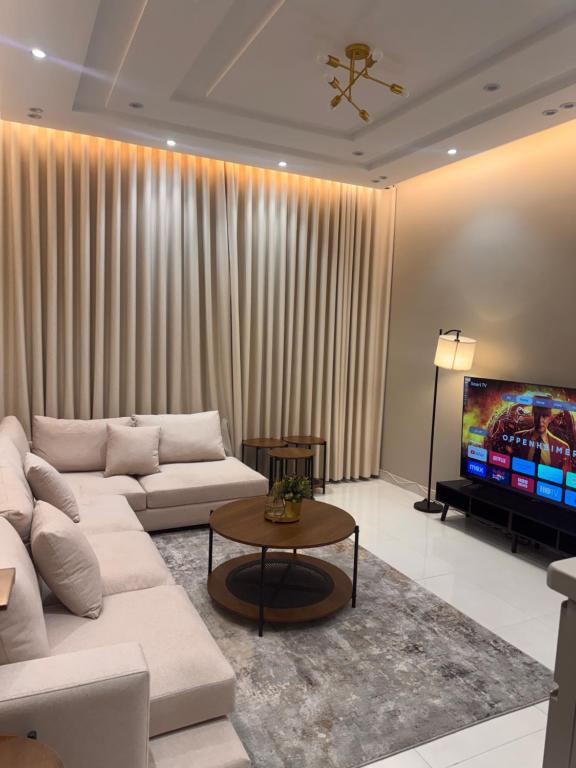 a living room with a white couch and a tv at دار مسك الفندقية in Medina