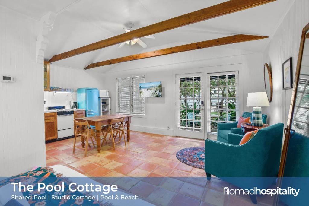 a living room with a blue couch and a table at Be A Nomad - Pool Access Studio Apartment - Jacksonville Beach Couples in Jacksonville Beach