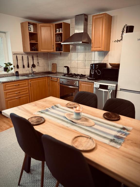 a kitchen with a wooden table with chairs around it at Jarmočná Apartmán in Stará Ľubovňa