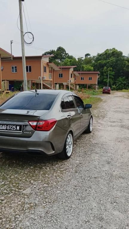 a silver car parked in a gravel parking lot at Apemen in Kuching