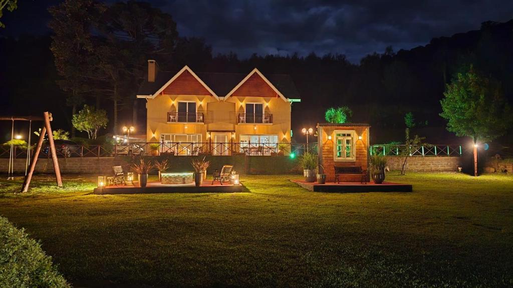 a large house with a yard at night at Palast Haus Hotel Boutique in Gramado