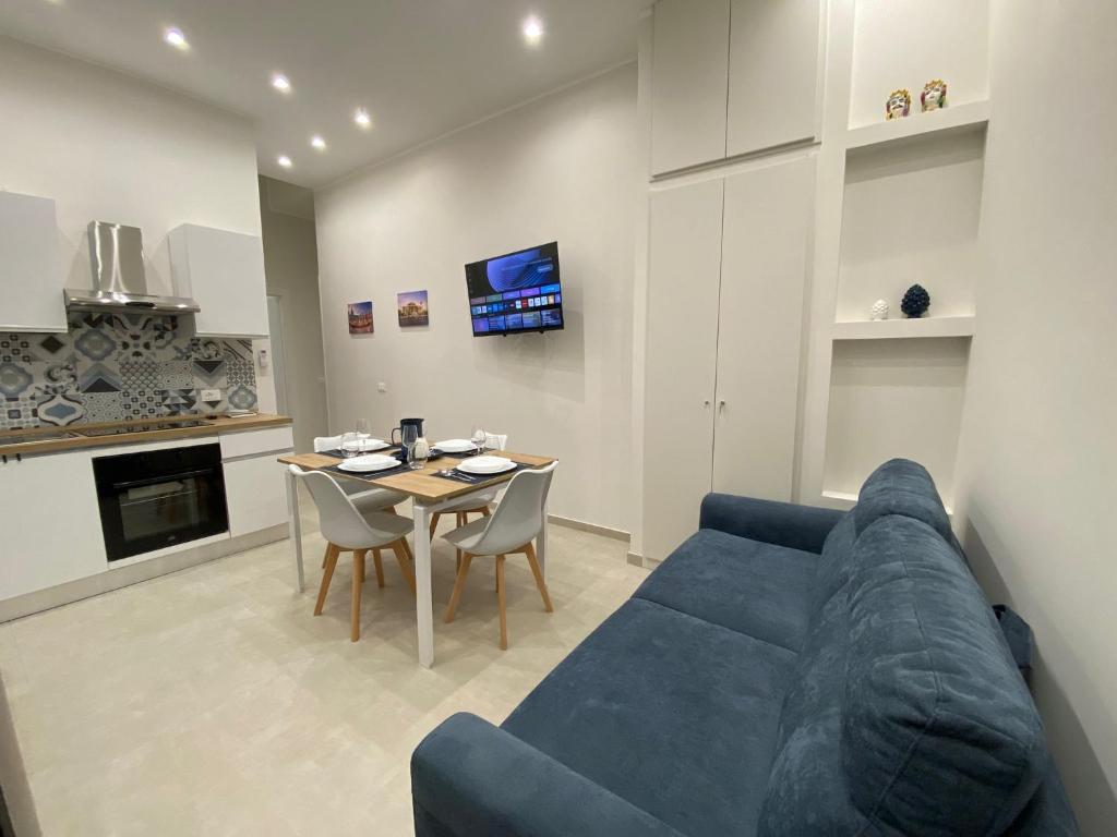 a living room with a blue couch and a table at Halisa Casa Vacanze in Palermo
