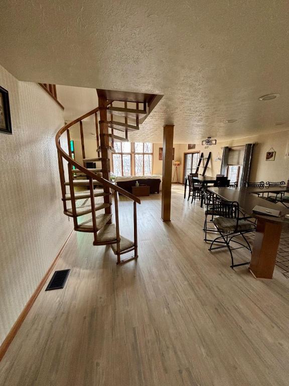 ein Wohnzimmer mit Wendeltreppe in einem Gebäude in der Unterkunft Falling Timber- A Frank Lloyd Wright Inspired Staycation in Canton