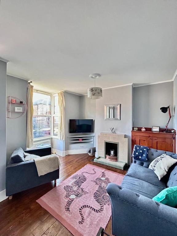 a living room with a blue couch and a fireplace at Charming 2 Bed Terrace in Central Caversham in Caversham