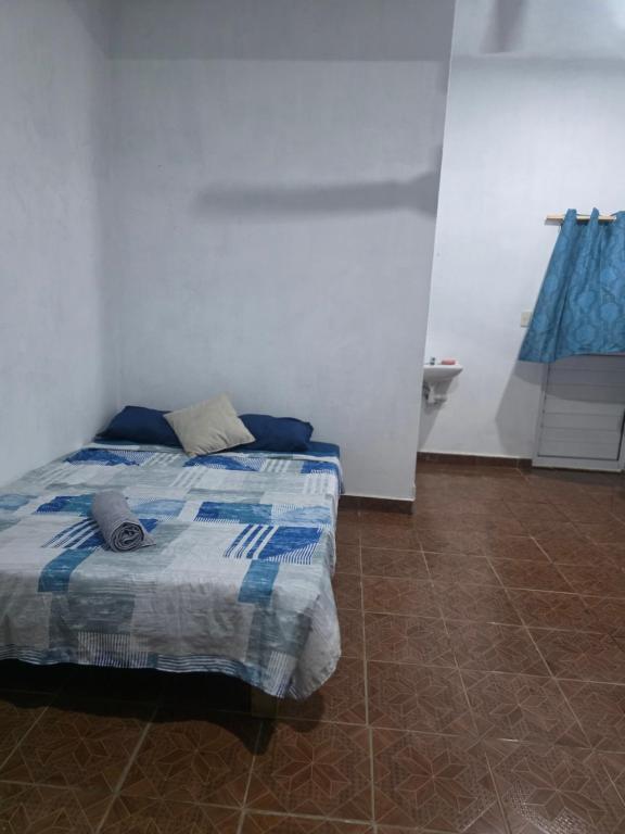 a bedroom with a bed with a blue and white blanket at Estudio Mar in Brisas de Zicatela