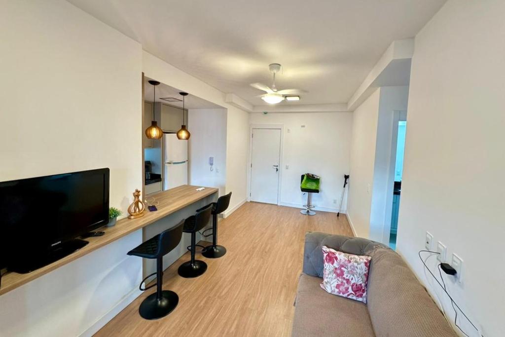 a living room with a couch and a table and a tv at APARTAMENTO PRÓXIMO AO CENTRo in Joinville