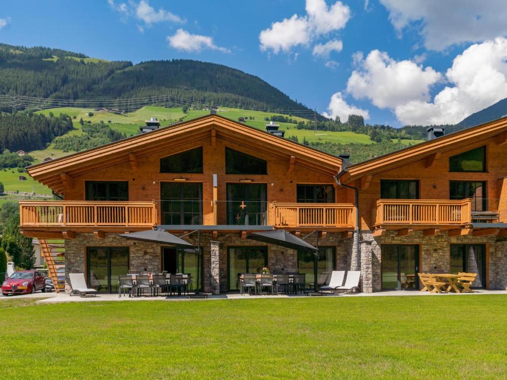 a large log building with tables and chairs at Pinzgau Lodge 1B in Wald im Pinzgau