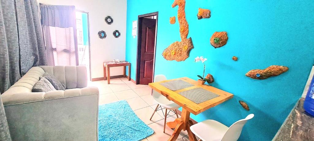 a living room with a blue wall with a table at Casa Galarous Island in Puerto Ayora