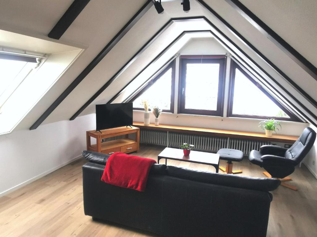 a living room with a black couch and a window at Charmante Ferienwohnung mit sonniger Loggia in Celle