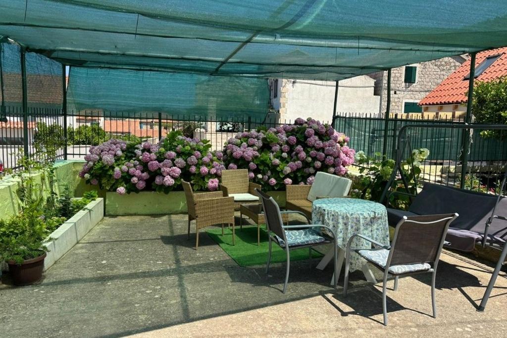 a patio with a table and chairs and flowers at Apartment Vis 2436a in Vis