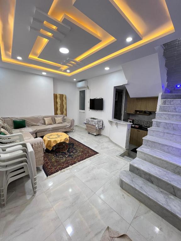 a living room with a staircase and a couch at Great duplex in Monastir in Monastir