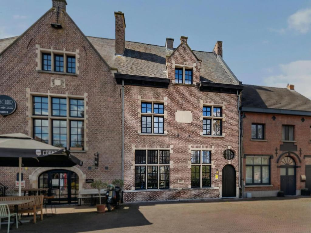 a large red brick building with a clock tower at Pastorie Liezele in Puurs