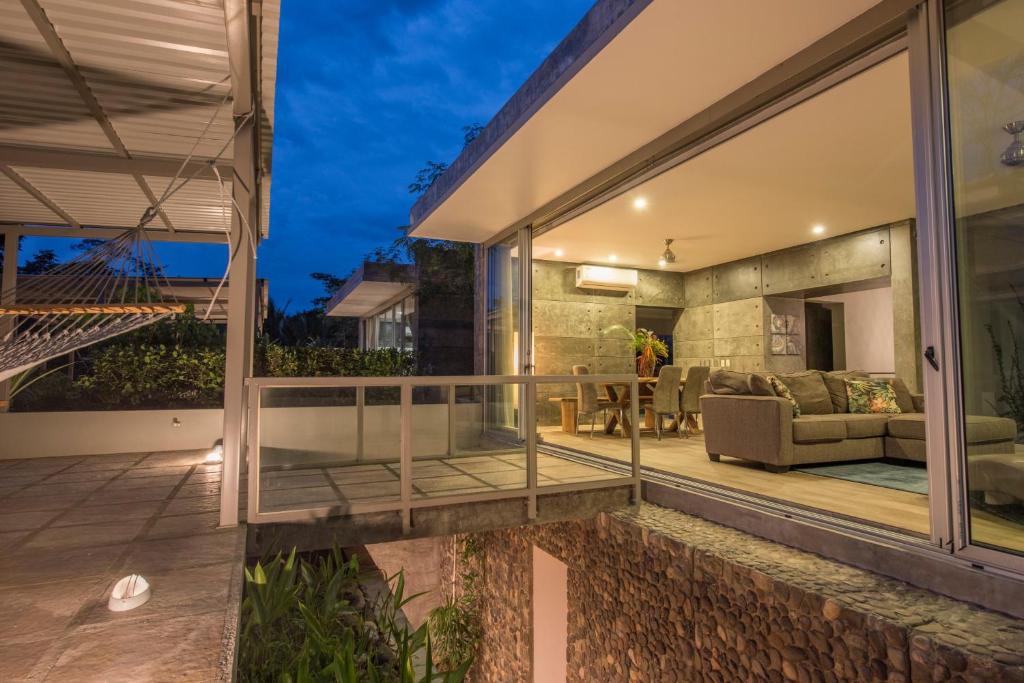 a glass extension of a house with a patio at Villa Los Laureles III, Private Pool, Nature Trails, Beaches in Esterillos Este